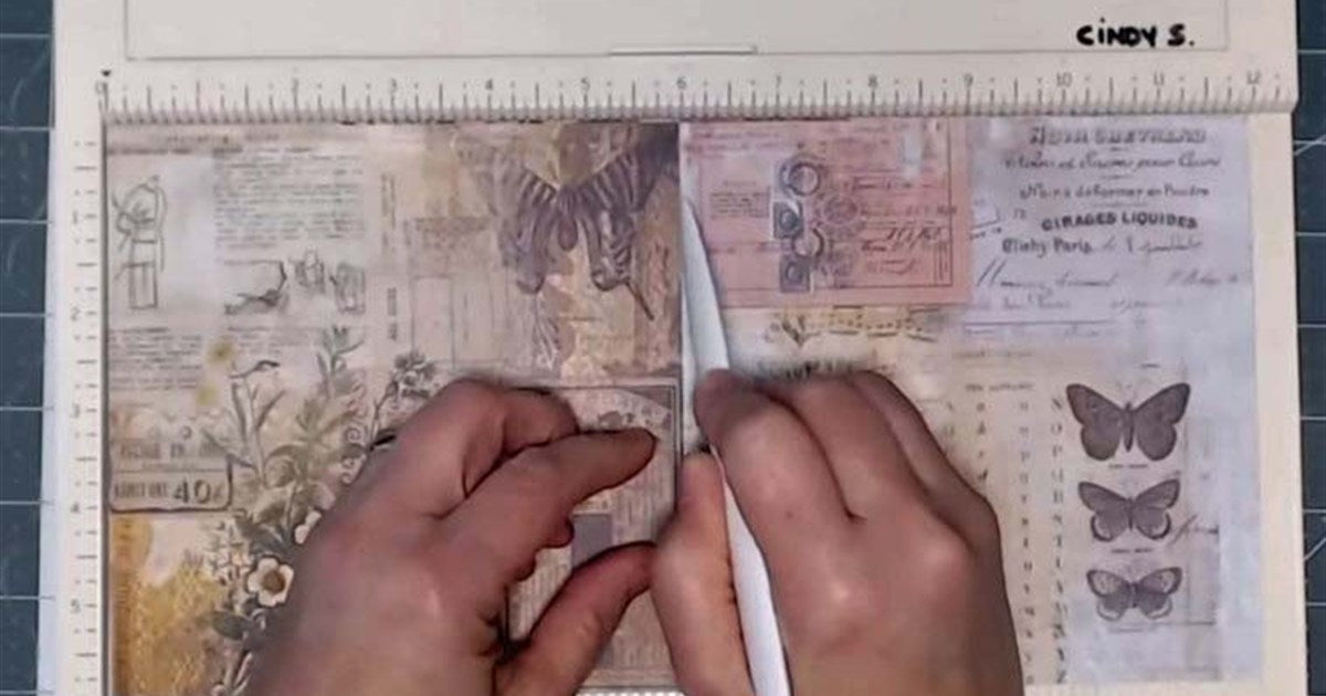 Scoring paper with a bone folder on a scoring board