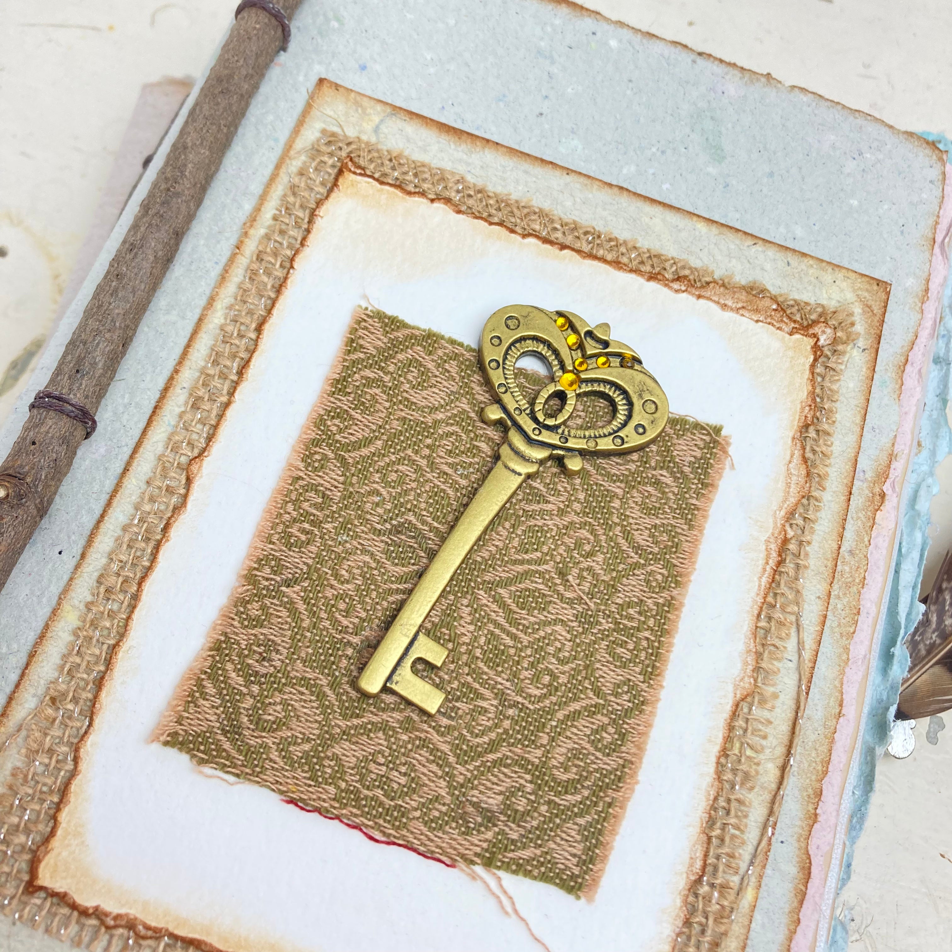 Art Journal with Handmade Paper Cover featuring a Vintage-style Key, Variety of Mixed Media Pages, Hand Sewn Binding with Stick Inserted