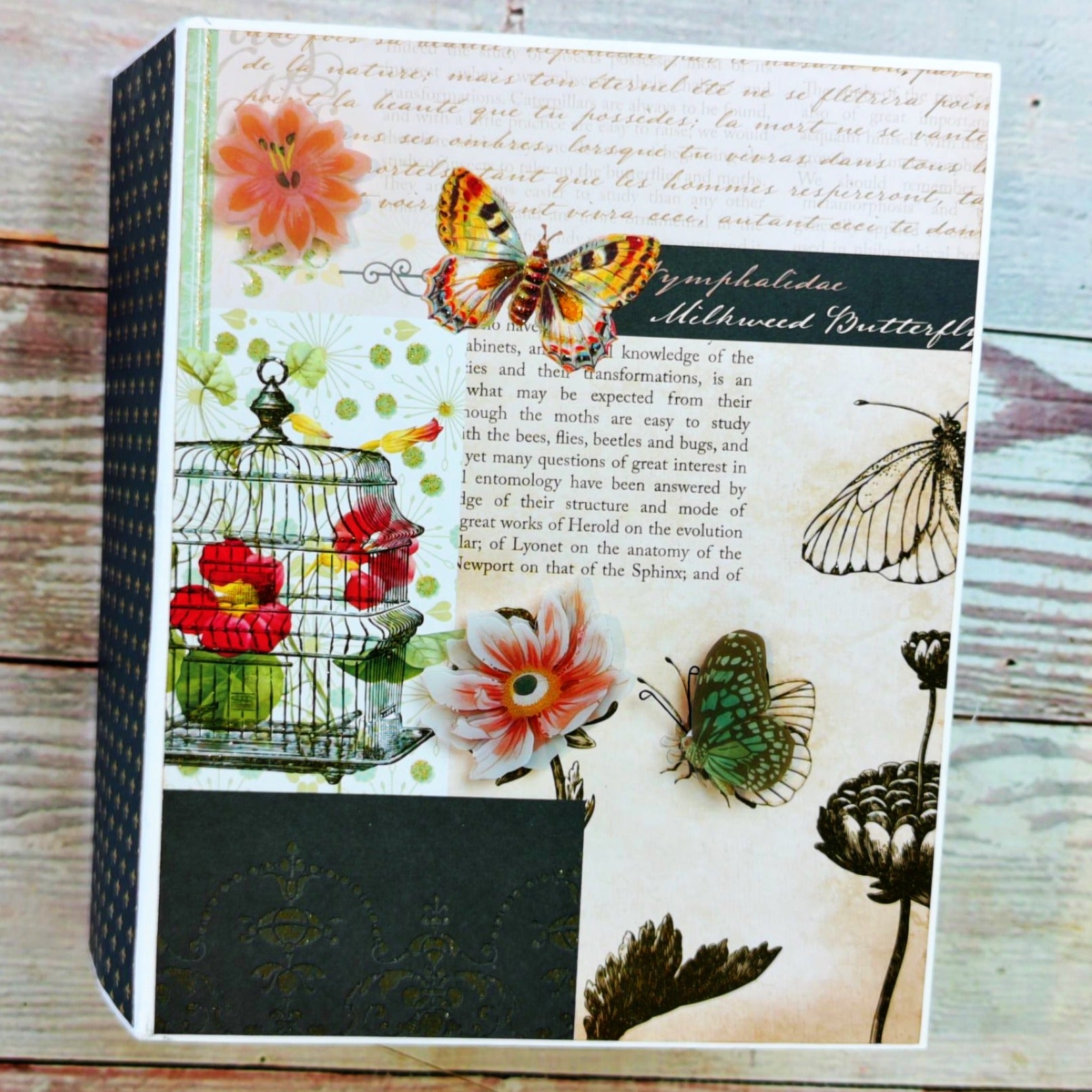 Decorative notebook with butterfly and floral design on a wooden surface