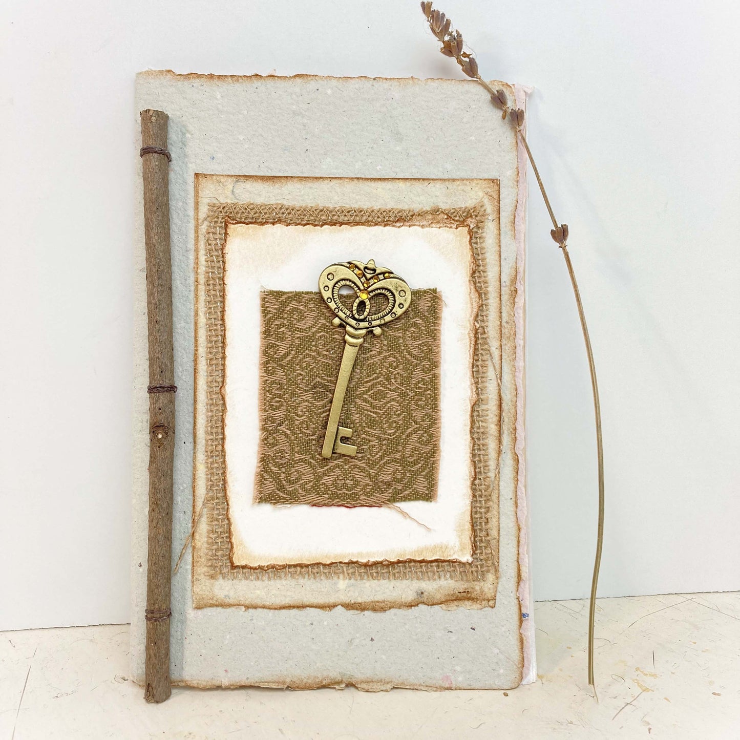 Art Journal with Handmade Paper Cover featuring a Vintage-style Key, Variety of Mixed Media Pages, Hand Sewn Binding with Stick Inserted